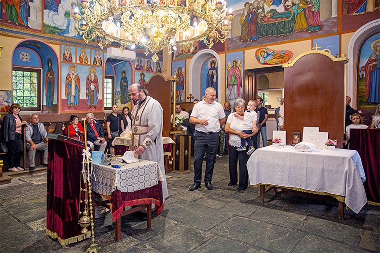 Отецът води ритуал Свето Кръщение в Белащински манастир Свети Георги Победоносец.