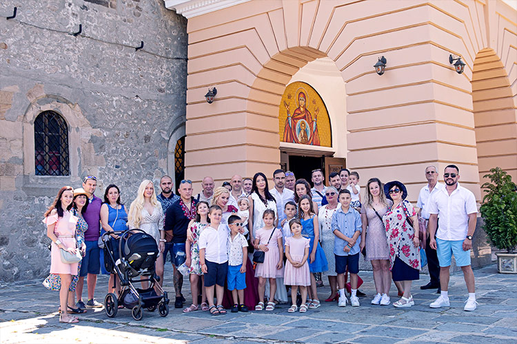Семейство със гостите на празника си застанли за снимка след края на ритуал Свето Кръщение в двора на Катедрален храм Успение Богородично.