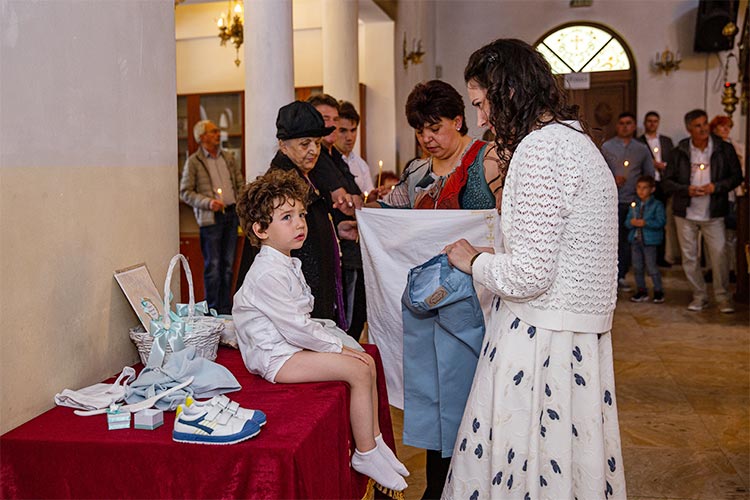 Майка облича новопокръстенето си момченце след кръщаване в купела по време на ритуал Свето Кръщение в храм Свети Клиемнт Охридски. град Пловдив.