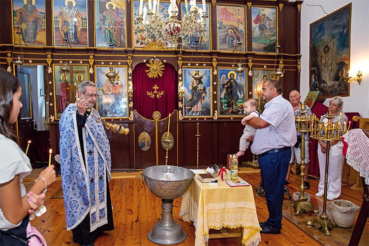 Ритуална обиколка на купела с новопокръстено момченце по време на ритуал Свето Кръщение в храм Свети Свети Константин и Елена, село Браниполе.