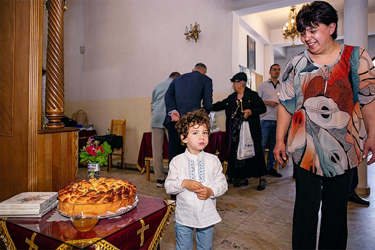 Новопокръстено момченце хапва от ритуалната погача след края на кръщението му в храм Свети Климент Охридски, град Пловдив.