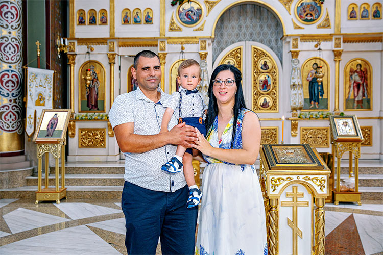 Майка и баща с новопокръстеното си момченце след края на кръщението му в храм Свети Николай Мирликийски Чудотворец, град Пловдив.