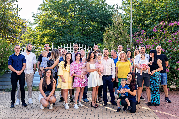 Гости и родители с новопокръстеното момиченце след края на кръщението му в двора на храм Свети Николай Мирликийски Чудотворец, град Пловдив.