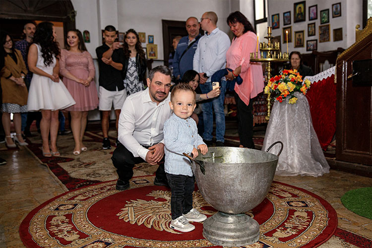 Момченце гледа с любопитство купела преди да е започнало кръщението му в храм Света Троица, град Стамболийски.